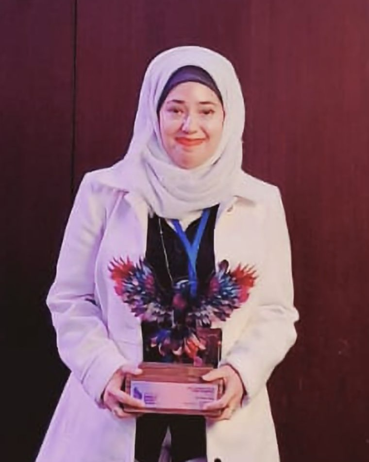 Dr Farina Riaz holding an award trophy